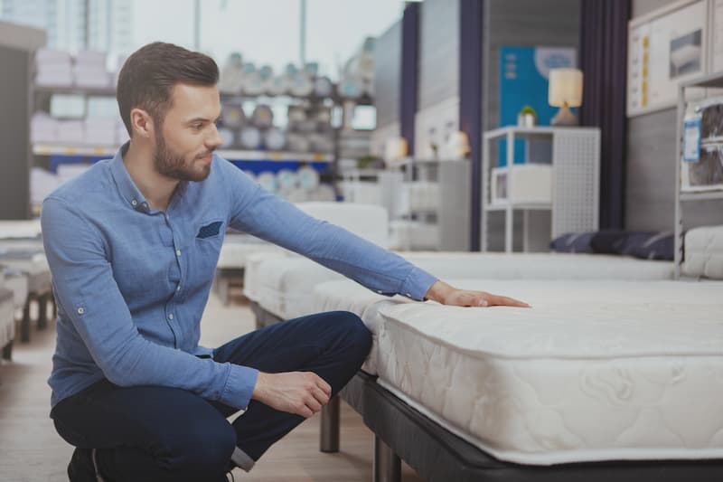 Man sitting near mattress