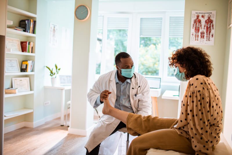 Close up of a doctor having an appointment with a patient with leg pain