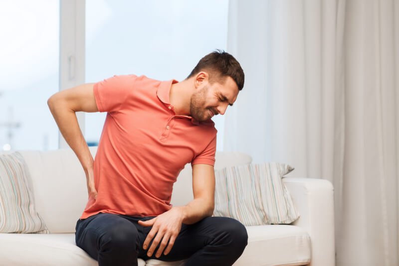 unhappy man suffering from pain in back